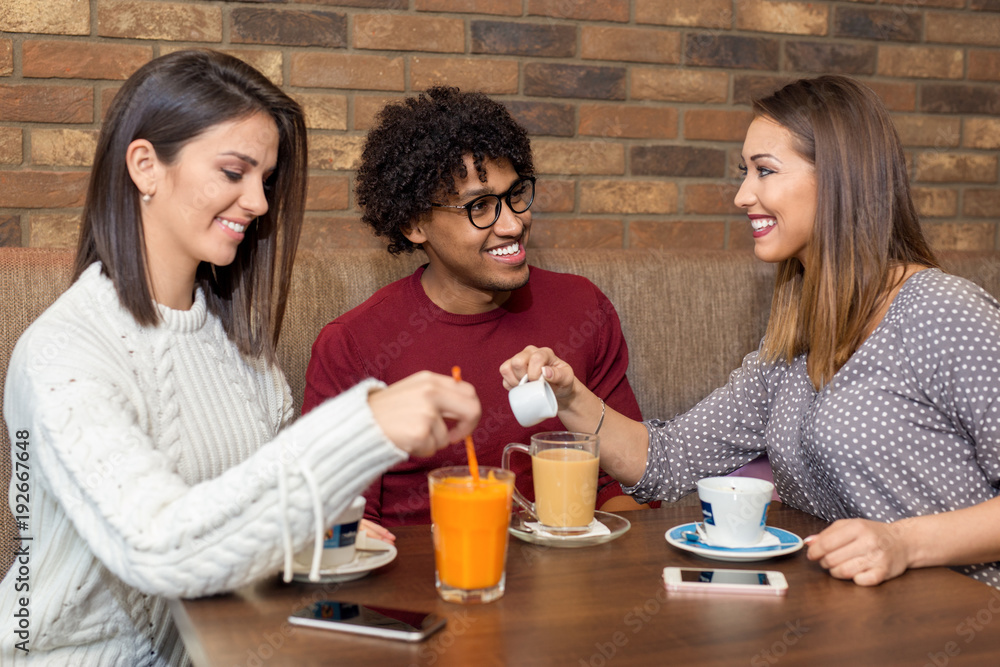 Group of friends sitting at cafe while two are flirting Group of friends sitting at cafe while two are flirting