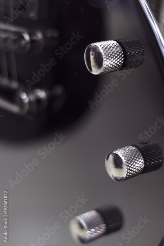 Electric guitar close-up with a soft focus of black color, tone controls, volume.
