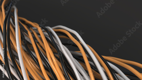 Twisted black, white and orange cables and wires on black surface