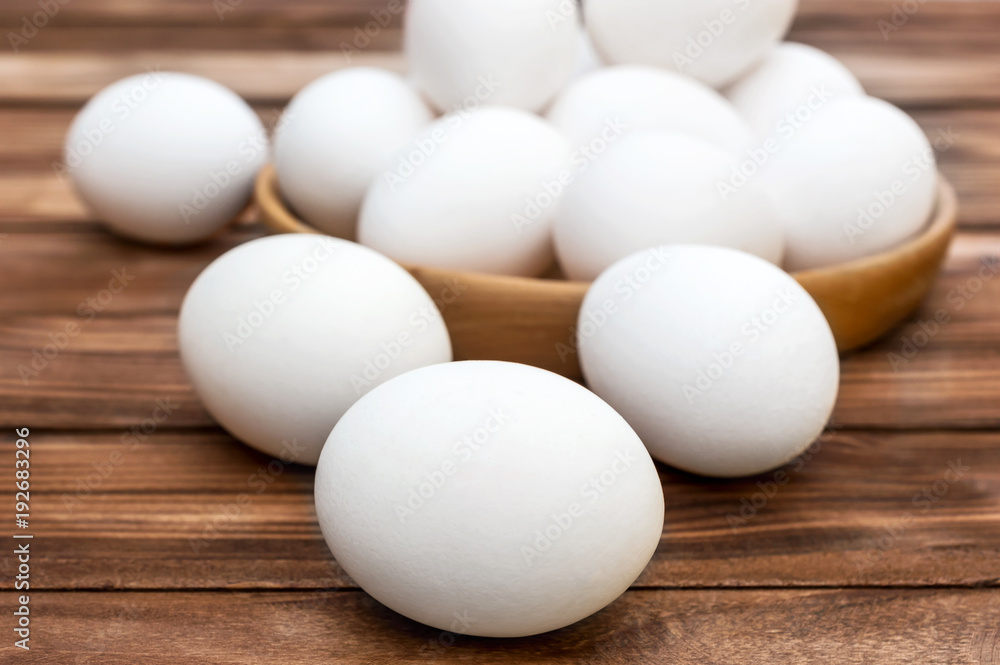 Eggs and wooden bowl with eggs on the table. Eggs and wooden bowl with eggs on the table.