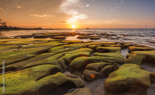 Sunset seascape with green moss on the ground at Kudat, Sabah Malaysia. image may contain soft focus due to long expose.