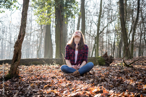 Woman sitting in forest and feel the nature