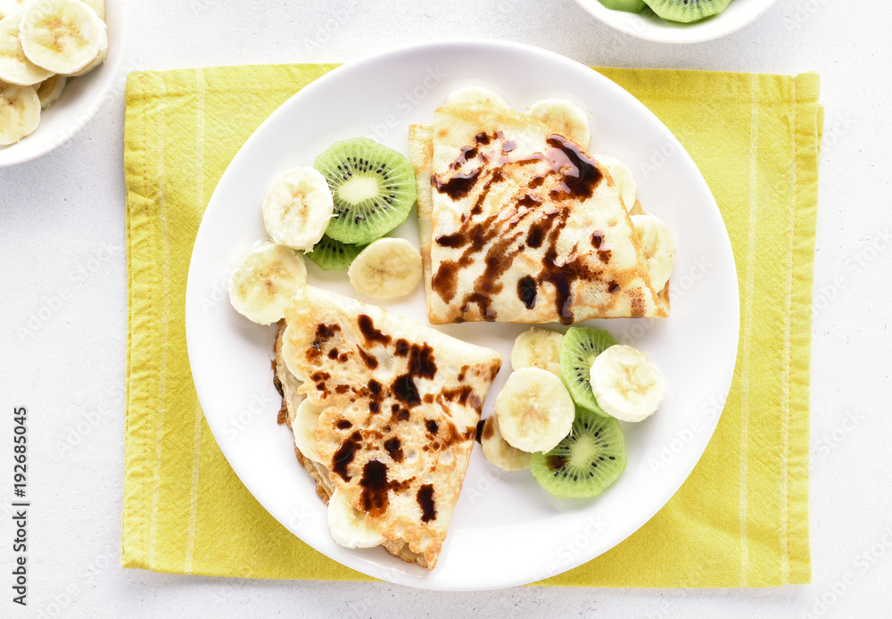 Crepes with banana, kiwi slices and chocolate sauce Crepes with banana, kiwi slices and chocolate sauce