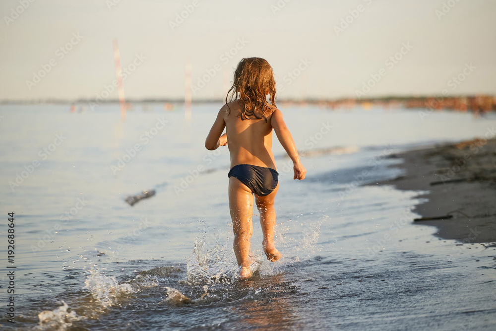 water fun. the girl runs along the seashore.