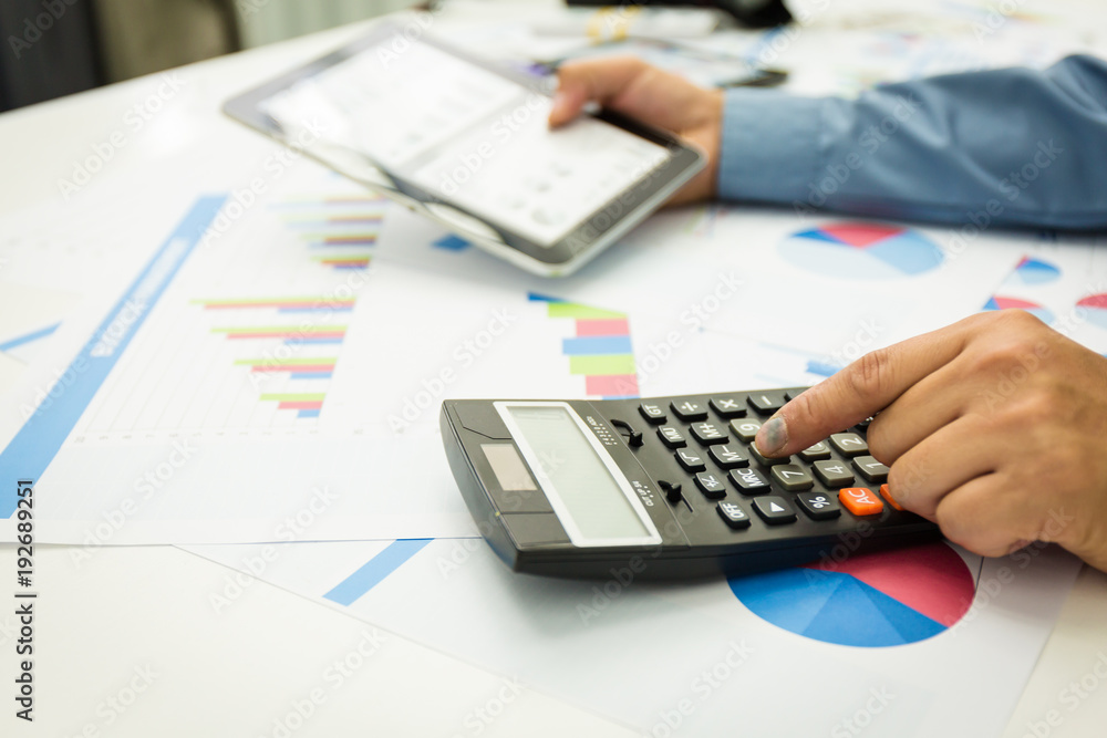 Businessman using a personal income tax calculator. Businessman using a personal income tax calculator.