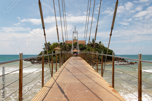 Perspective view of the bridge to Matara Parevi Duwa buddhist temple, Sri Lanka. photo
