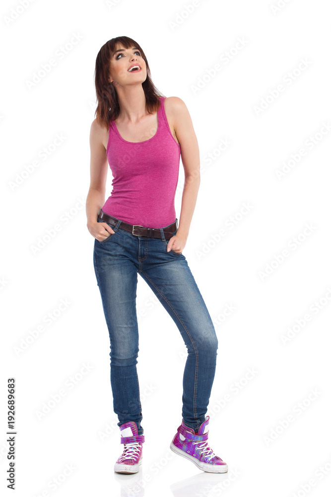 Smiling Casual Woman Is Holding Hands In Pockets And Looking Up Smiling Casual Woman Is Holding Hands In Pockets And Looking Up