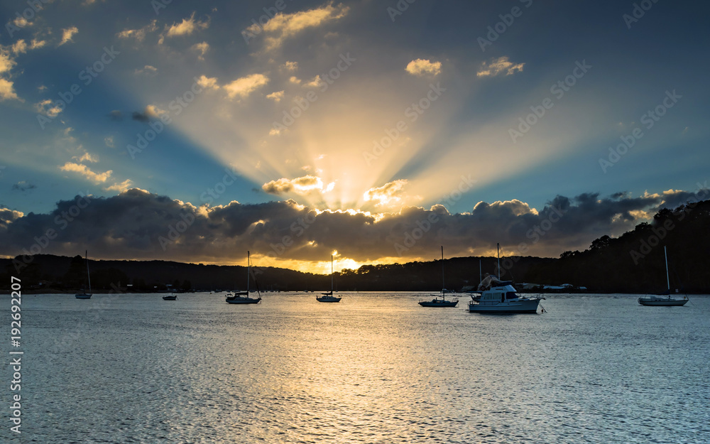 Sunrise Waterscape with Boats and Sun Rays