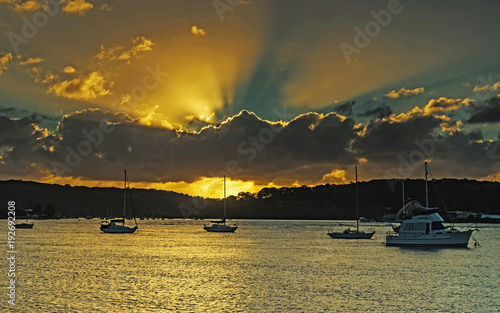 Sunrise Waterscape with Boats and Sun Rays photo