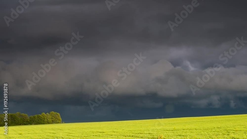 Alarming view of the vivid lawn and dark ominous clouds. Dramatic and mystery scene. Wonderful natural background. Beauty world. Climate change. Time lapse clip, interval shooting in HD 1080 video.