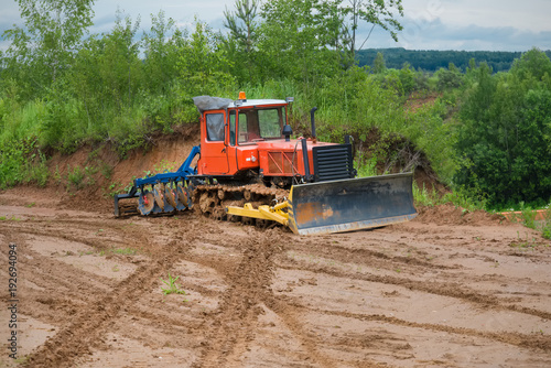 Tractor bulldozer on a caterpillar drive is parked in the mud. Concept road construction.