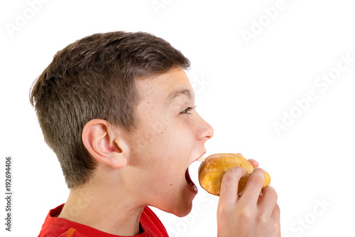 Young caucasian teenage boy eating a pasty