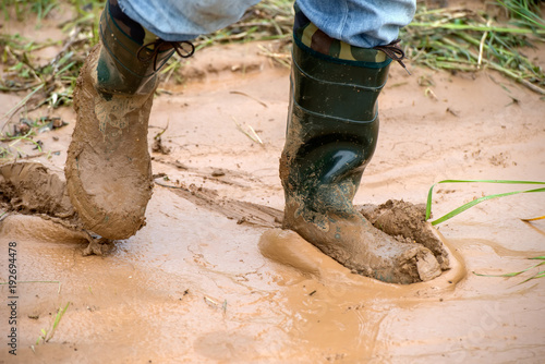 Canvas Print Tourists in rubber boots is on dirt