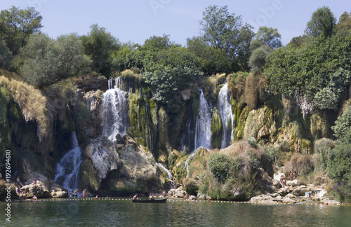 Kravica waterfalls in Bosnia Herzegovina, with few people bathing under it