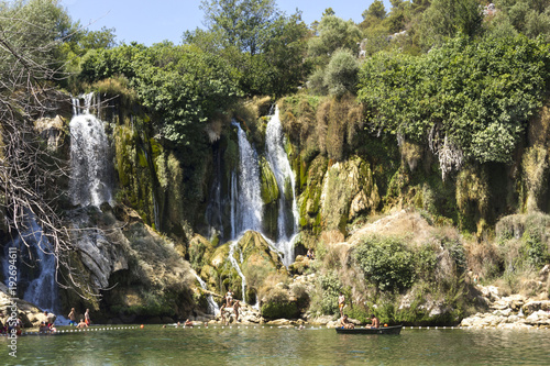Kravica waterfalls in Bosnia Herzegovina  with few people bathing under it