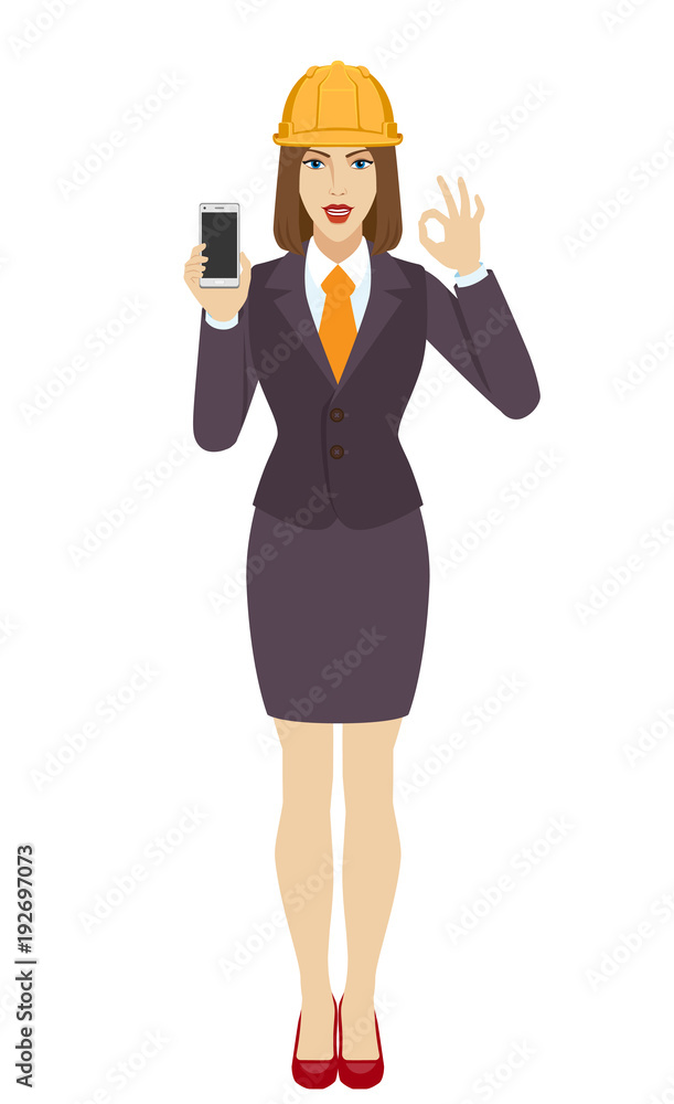 Businesswoman in construction helmet holding a mobile phone and  show a okay hand sign