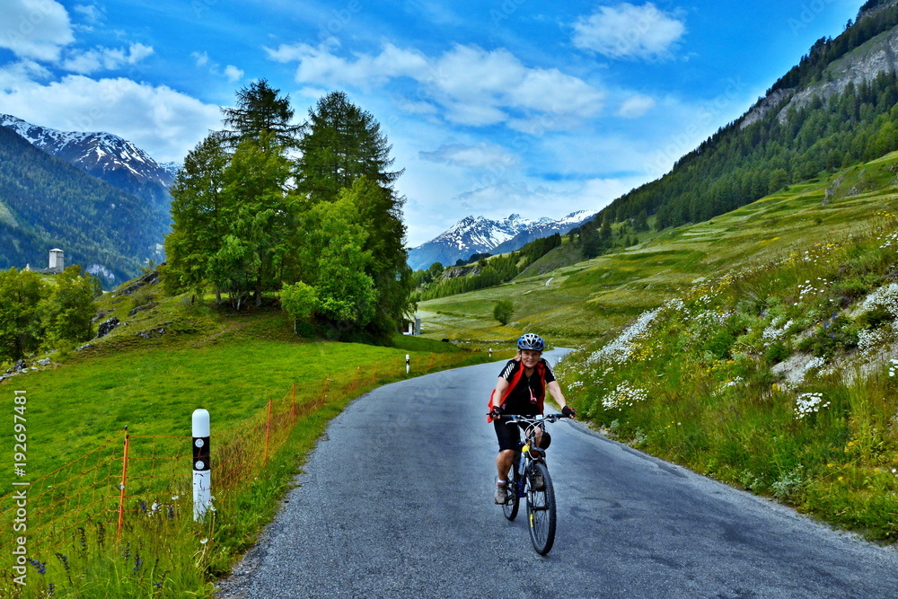 Swiss Alps-view on the cyclist on the mountain road  above Ardez