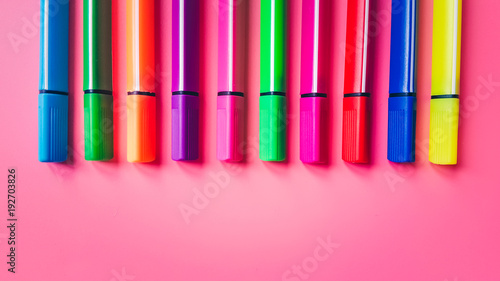 Set of multicolored markers on a pink background. Office tools. The concept of education and creativity.