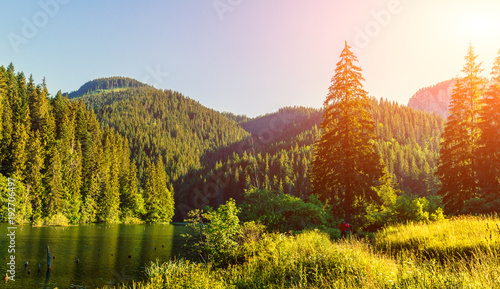 Wonderful summer morning. majestic mountain lake in mountain. under sunlight. unusual sunny landscape. Lacul Rosu the Red Lake or Killer Lake. location. Evropa. Eastern Carpathian. Romania. photo