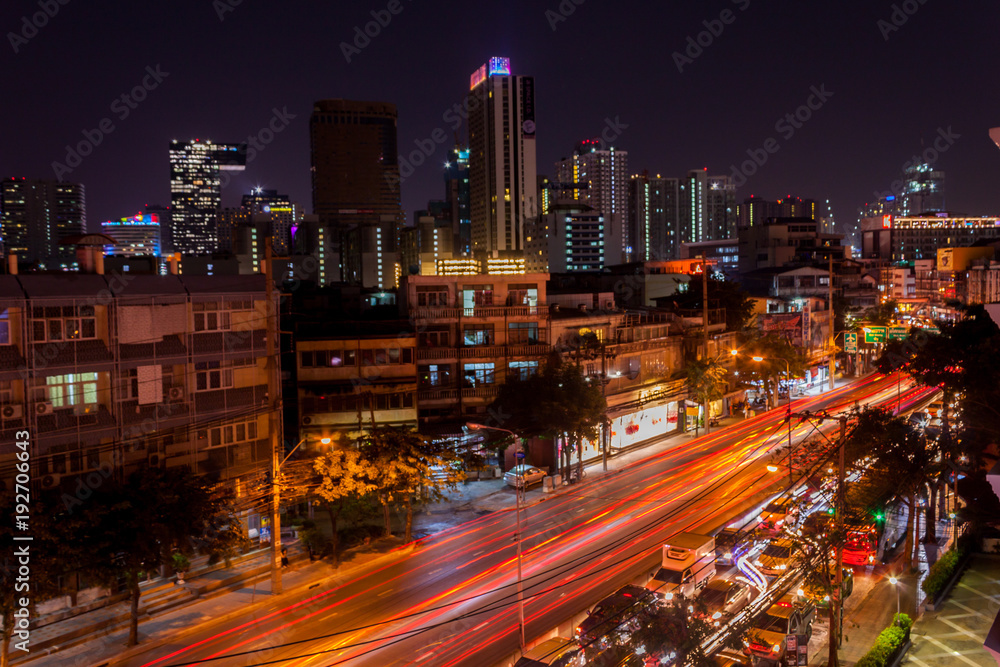 Traffic jam on the street at night And lighting from buildings and cars in Bangkok.
