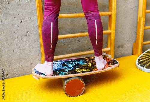 Amateur sport man exercising on a balance-board at indoor fitness gym, modern leisure concept photo