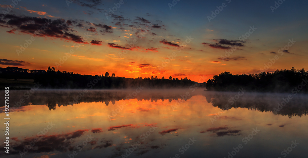wonderful misty morning. majestic sunrise over the lake. picturesque dramatic scene.
