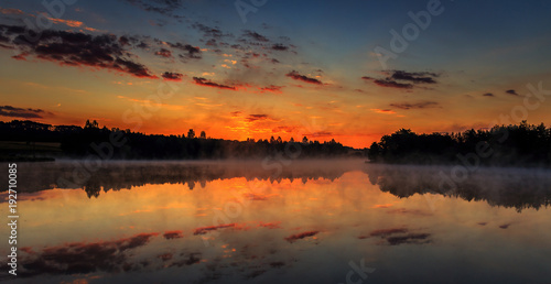 wonderful misty morning. majestic sunrise over the lake. picturesque dramatic scene.