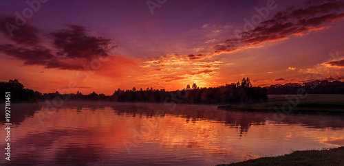 wonderful misty morning. majestic red sunrise over the foggy lake