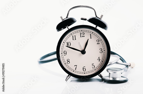 Regular or routine medical examination concept, stethoscope and alarm clock on white background