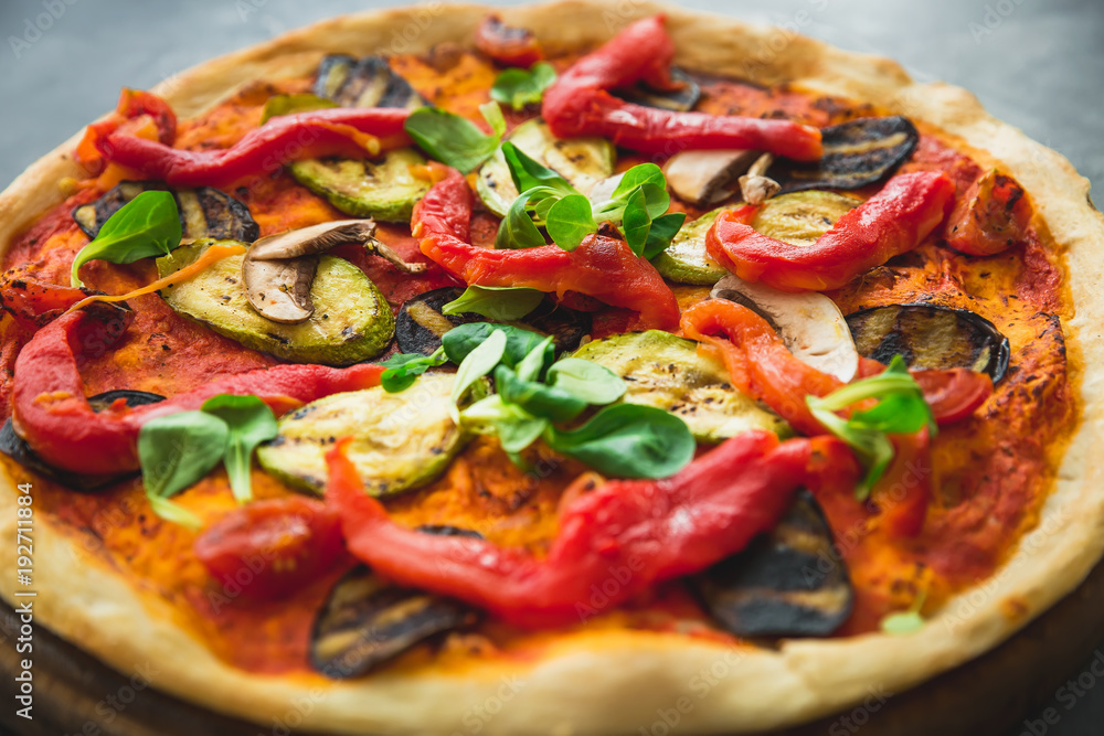 Vegetarian pizza with pepper, tomato, zucchini on dark background. Flat lay, top view. Food background