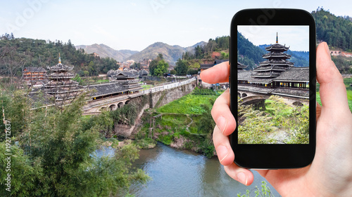 tourist photographs temple on Chengyang bridge photo