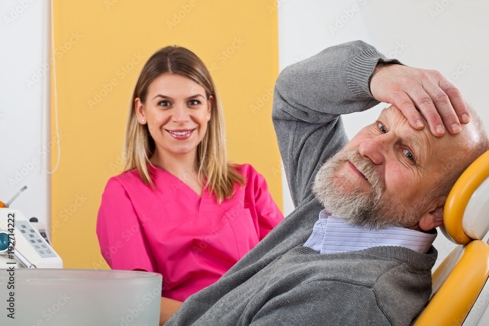 Young female dentist with elderly patient