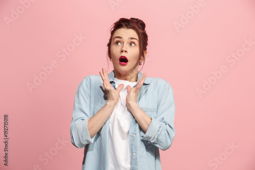 Beautiful woman looking suprised isolated on pink