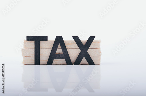 TAX word and reflection on white surface