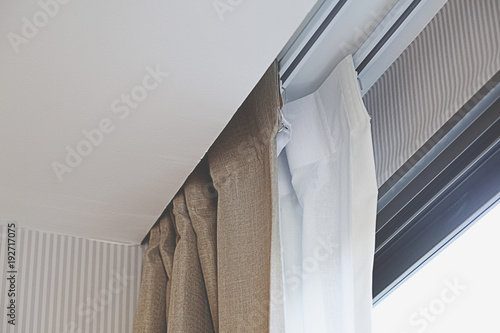 Part of beautifully white curtain on the window in the room.  photo