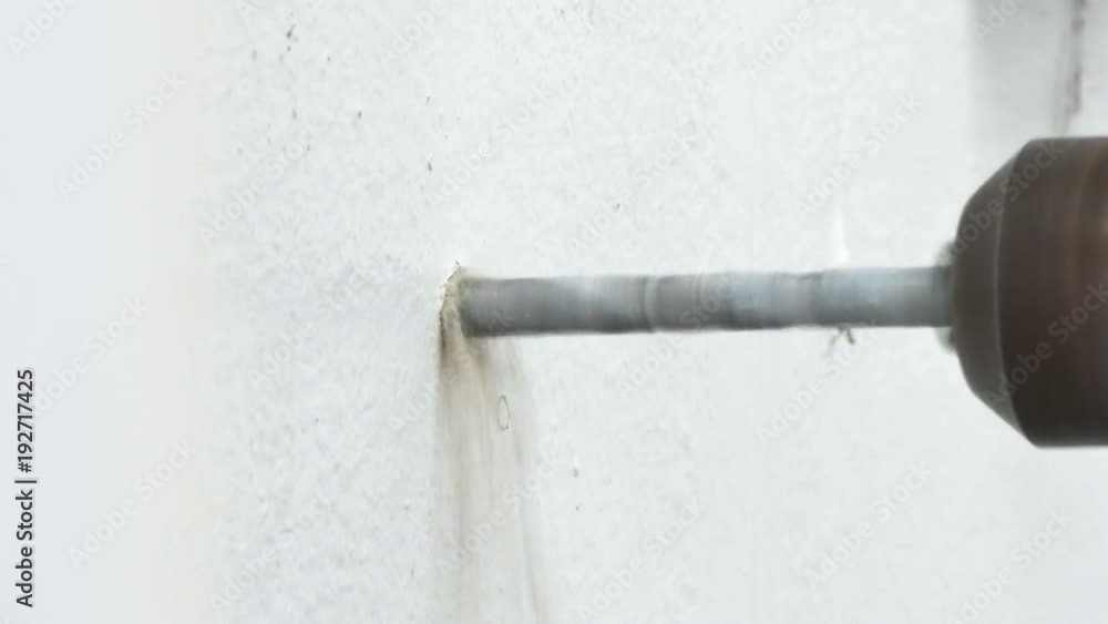 Close up shot electric driller bit spin to drilling cement concrete white wall for hold with ambient sound Close up shot electric driller bit spin to drilling cement concrete white wall for hold with ambient sound