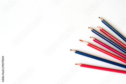 several colored pencils are scattered on a white sheet of paper