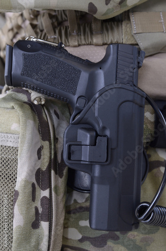Pistol of soldier of KORD (police strike force, Ukrainian SWAT) placed in a holster photo