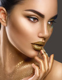 Fashion art makeup. Portrait of beauty woman with golden skin. Glamour shiny professional makeup