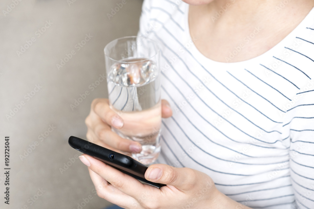 Closeup young woman holding drinking water glass in her hand. Health care concept. Closeup young woman holding drinking water glass in her hand. Health care concept.