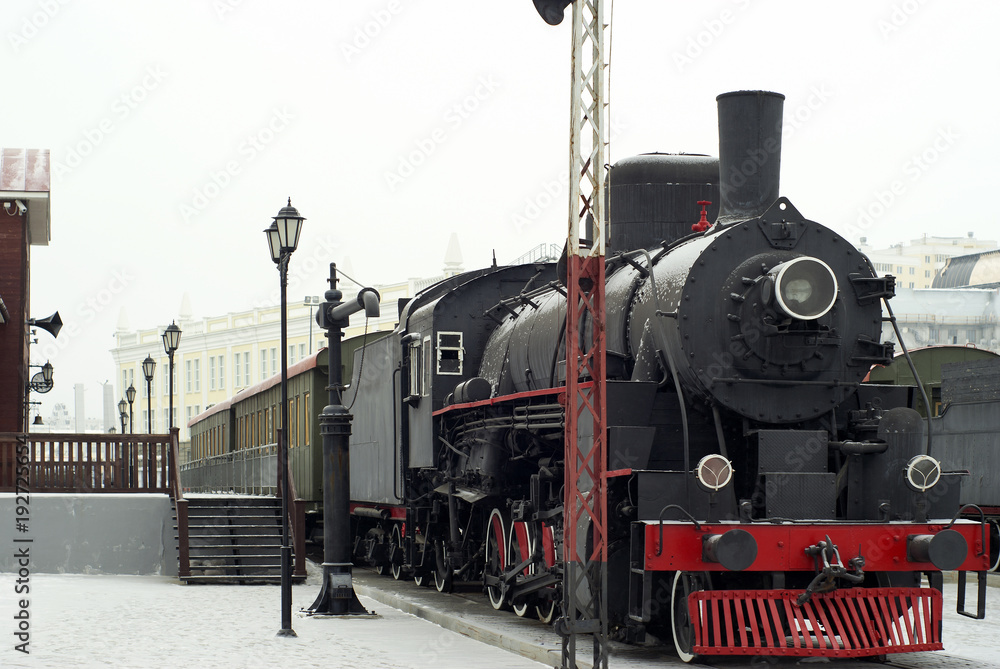 Fototapeta premium vintage steam locomotive with wagons standing at the railway station in winter