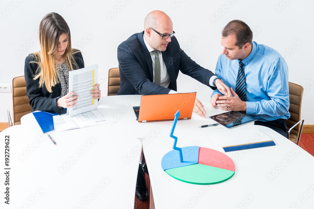 A business team of three sitting in office and planning work. Using laptop to make business strategy. Startup in developement. A business team of three sitting in office and planning work. Using laptop to make business strategy. Startup in developement.
