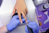 Repair old gel nails with a nail grinder in the nail salon. The process of replacing old gel nails with new ones