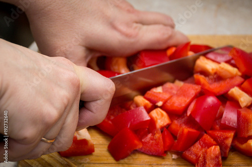 Close up of hands cutting vegetables with a knife