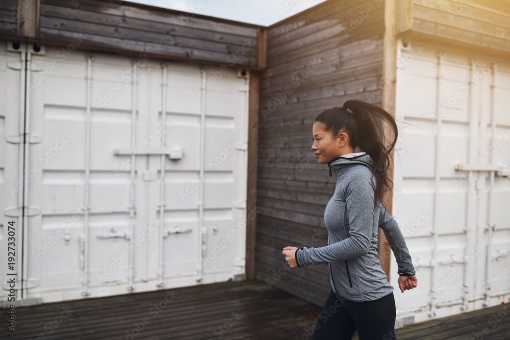 Fit young Asian woman in sportswear jogging outdoors Fit young Asian woman in sportswear jogging outdoors