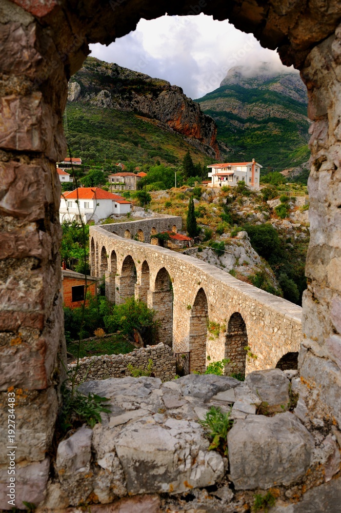 Bar, Montenegro, view of aqueduct in Stari Bar through stone window in fort wall 