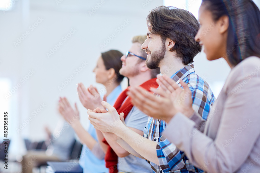 Row of young businesspeople clapping their hands after report of speaker Row of young businesspeople clapping their hands after report of speaker