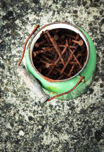 old green kettle filled with rusty nails