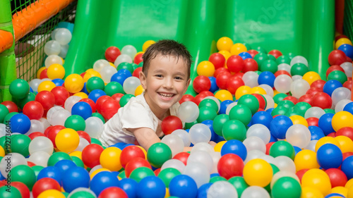 The child is playing on the court with balls.