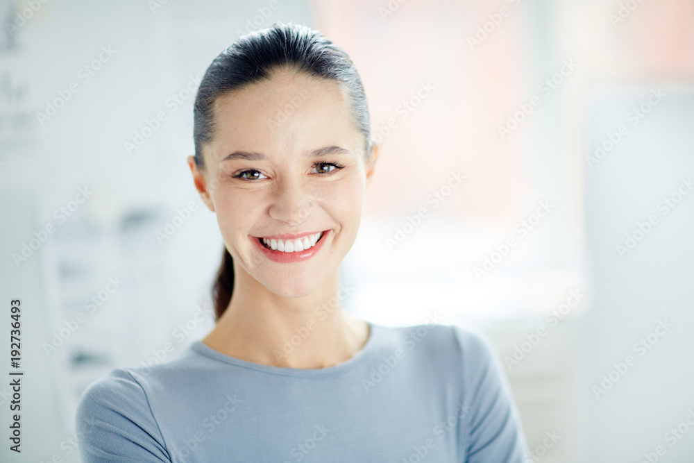 Happy young specialist or employee with toothy smile looking at camera Happy young specialist or employee with toothy smile looking at camera